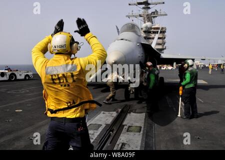 Petty Officer 3. Klasse Patrick Wight Signale an die Piloten eines F/A-18-Flugzeugen vor dem Start der Flight Deck des Flugzeugträgers USS Ronald Reagan (CVN 76) im Arabischen Meer am 6. Juni 2011. Das Ronald Reagan und Carrier Air Wing 14 werden in den USA 5 Flotte Verantwortungsbereich Durchführung schließen-Einsätze im Rahmen der Operation Enduring Freedom eingesetzt. Stockfoto