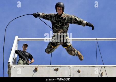 Us Navy Lieutenant Ryan Ramsden rappels aus einem Turm beim Training mit Mitgliedern der australischen Northern Territory Tactical Response Group während der Übung Talisman Sabre 2011 in Darwin, Australien, am 20. Juli 2011. Talisman Säbel ist eine bilaterale Übung australische und US-Streitkräfte in die Planung und Durchführung der kombinierten Operationen zu trainieren. Ramsden ist für die Beseitigung von Explosivstoffen Mobile Unit 5 zugeordnet. Stockfoto