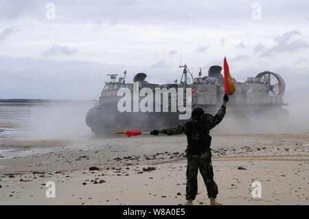 Ein U.S. Navy sailor mit Beachmaster Einheit 1 leitet eine Landing Craft, Luftpolster in Richtung Strand bei einem Transport zu Wasser Übung mit der Australischen Armee an der Shoalwater Bay Truppenübungsplatz in Queensland, Australien, während Talisman Sabre 2011 am 15. Juli 2011. Talisman Säbel ist eine kombinierte Biennale Übung zwischen den USA und der australischen Streitkräfte entwickelt, die sich sowohl Nationen als "Fähigkeit zur regionalen Möglichkeiten zu reagieren, zu verbessern. Stockfoto