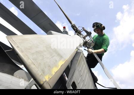 U.S. Navy Petty Officer 2nd class Branden Rucker führt die Instandhaltung Korrosion an den Heckrotor eines SH-60F Seahawk Hubschrauber an Bord des Flugzeugträgers USS Ronald Reagan (CVN 76) im Südchinesischen Meer auf Aug 9, 2011 Helikopter Anti-Submarine Squadron 4 zugewiesen, um zu steuern. Der Ronald Reagan ist unterwegs in den USA 7 Flotte Verantwortungsbereich. Stockfoto