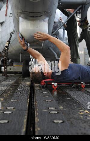 U.S. Navy Petty Officer 3rd Class Corey Miller, zu Hubschrauber Anti-Submarine Squadron Licht 46 zugewiesen, wäscht die Unterseite Heck eines SH-60B Sea Hawk Hubschrauber auf dem Flugdeck der geführten-missile Cruiser USS Anzio (CG68) im Atlantischen Ozean am Dez. 6, 2011. Die Anzio ist die Durchführung einer 7-monatigen Einsatz in den USA am 5. und 6 Flotte Verantwortungsbereiche. Stockfoto