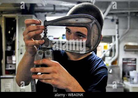 U.S. Navy Seaman Kaleb Weiß passt eine nietzange während der Reparatur eines Schadens Eimer an Bord der Flugzeugträger USS Carl Vinson (CVN 70) im Indischen Ozean am 31.01.10., 2012. Weiß ist die Flugzeuge zwischen Instandhaltung zugeordnet. Stockfoto