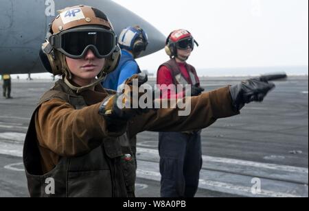 .S. Navy Airman Elaine Ketola (links) Signale für den Start einer F/A-18C Hornet aircraft von Strike Fighter Squadron 192 auf dem Flugdeck der Flugzeugträger USS John C Stennis (CVN 74) im Arabischen Meer am 31.01.2012. Die Stennis ist in die USA 5 Flotte Verantwortungsbereich eingesetzt Maritime Security Operations und Einsätze im Rahmen der Operation Enduring Freedom zu führen. Stockfoto