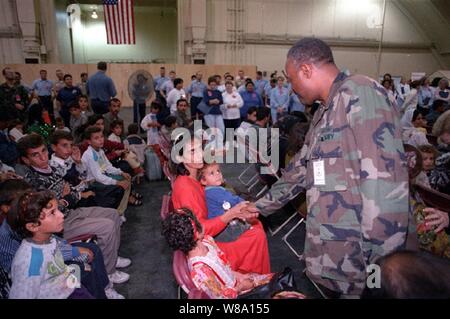 U.S. Navy hinten Adm. David Brewer III begrüßt die Mitglieder der ersten Gruppe von kurdischen Umsiedler bei Andersen Air Force Base, Guam, Sept. 17, 1996, auf einem zivilen Charterflug aus der Türkei im Rahmen der Operation Pazifik Haven. Diese kurdische Asylanten sind die ersten von rund 2.000 ausländische Service-Bürgern und deren Familien, die mit den Vereinigten Staaten governmentХs humanitären Bemühungen im Norden des Irak verbunden waren. Sie werden geschützt werden und bei Andersen Air Force Base und auf einen Fall bearbeitet von Fall zu Fall für den Eintritt in den kontinentalen Vereinigten Staaten so schnell wie möglich Stockfoto