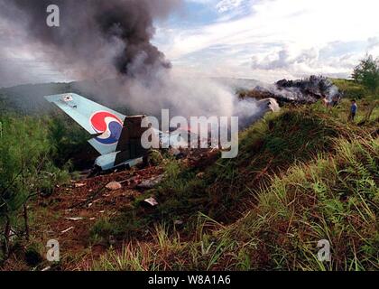 Das Heck der Korean Airlines Flug 801 steht grafisch an der Unfallstelle in den frühen Morgenstunden des 6. August 1997 U.S. Navy, U.S. Air Force, U.S. Coast Guard und zahlreichen zivilen Rettungskräfte, die derzeit die Unterstützung der Such- und Rettungseinsätze von KAL Flug 801, evakuierte Überlebende aus der Absturzstelle in den frühen Morgenstunden des 6. August. Stockfoto