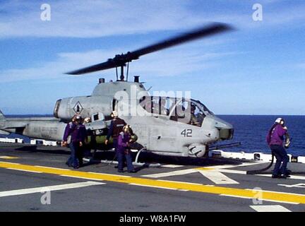 Flight Deck Crew Mitglieder an Bord der Amphibisches Schiff USS Wasp (LHD 1) Hot tanken ein US Marine Corps AH-1W Super Cobra am 31.01.17, 1998, während der Gemeinsamen Task Force Übung 98-1. Mehr als 30.000 US-Militärs sind die Teilnahme an der Übung, die Prüfung ist die gemeinsame Kräfte auf ihre Fähigkeit, schnell zu implementieren und zu gemeinsamen Aktionen während einer Krise führen. Alle Zweige der Streitkräfte sind Ausbildung, die Seite an Seite mit den neuesten Fortschritten in der Technologie in einem simulierten hohe Bedrohungslage, die Luft-, See- und Ground Operations. Die Super Cobra ist zu Hubschrauber befestigt Stockfoto