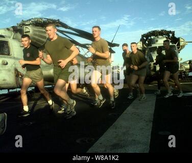 Us-Marines vom 3 Platoon, India Company, führen Sie morgen körperliches Training auf dem Flugdeck der USS Guam (ZG-9) als das Schiff im Persischen Golf am 28.02.1998. Die Guam und seine eingeschifft, combat ready Marines aus der 24 Marine Expeditionary Unit, spezielle Operationen in der Lage sind, die in den Persischen Golf als Teil einer Kraft Augmentation in Südwestasien. Die Guam ist homeported in Norfolk, Virginia. Stockfoto