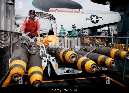 Petty Officer 3rd Class William Bailey Jr. Transporte MK-82 500 Pfund Bomben aus einem Waffen Aufzug in den Flight Deck an Bord der Flugzeugträger USS George Washington (CVN 73 wie das Schiff dampft im Persischen Golf am 10.02.1998. Die Washington Battle Group, die in den Persischen Golf zur Unterstützung der Operation Southern Watch, der USA und der Koalition die Durchsetzung der no-fly-Zone im Süden des Irak. Bailey ist ein Marine Aviation ordnanceman aus Louisburg, N.C. Stockfoto