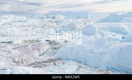 Drone Bild des Eisbergs und Eis von Gletscher in der Arktis Natur Landschaft auf Grönland. Luftbild Drohne Foto von Eisbergen in Ilulissat Eisfjord. Durch den Klimawandel und die globale Erwärmung betroffen. Stockfoto