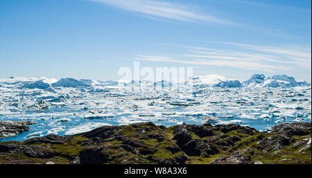 Eisberg und Eis vom Gletscher in den arktischen Natur Landschaft auf Grönland. Luftbild Drohne Bild von Eisbergen in Ilulissat Eisfjord. Durch den Klimawandel und die globale Erwärmung betroffen. Stockfoto