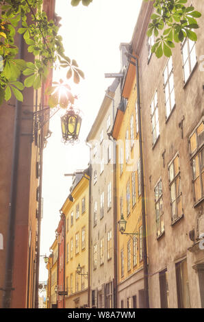 Schönen sonnigen Gasse in Gamla Stan, der Altstadt, Stockholm, Schweden Sommerurlaub farbenfrohe Gebäude, absichtlich überbelichtet mit Sonne, Lens Flare. Stockfoto