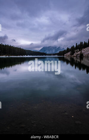 Winterliche Reflexionen am Johnson Lake im Banff National Park in Alberta, Kanada Stockfoto