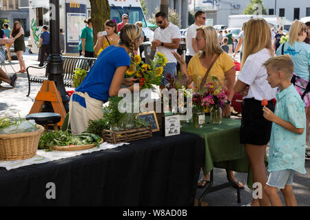 Eine Blume Anbieter am Fort Wayne's Bauernmarkt fördert ihr Blumen zu potenziellen Kunden in der Innenstadt von Fort Wayne, Indiana, USA. Stockfoto