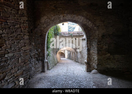 Steinernen Torbogen in der mittelalterlichen Wehrkirche von Birthälm, Rumänien, mit gepflasterten Weg. Stockfoto