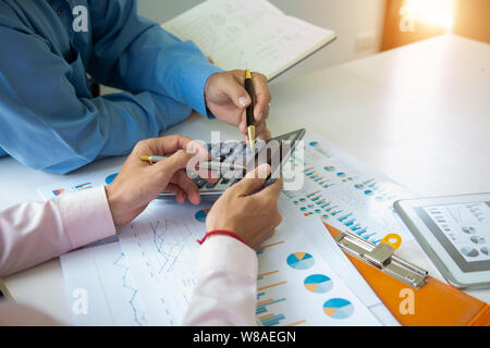 Team Geschäftsmann mit Taschenrechner und die Feder auf Papier im Büro. Buchhaltung Konzept. Stockfoto