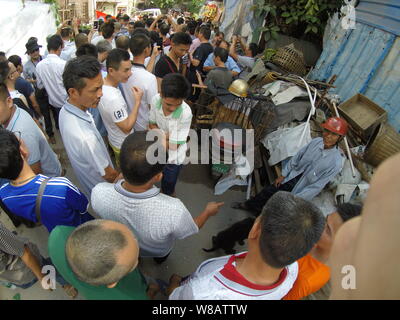 Leute neben eingesperrten Hunde an einem freien Markt während der yulin Hund essen Festival in Yulin City, South China Guangxi Zhuang Autonom, getötet zu werden. Stockfoto