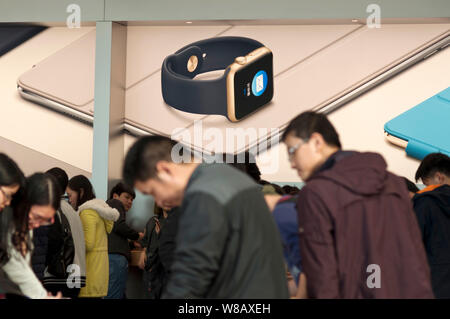 ------ Kunden versuchen, elektronische Produkte vor eine Werbung für die Apple Watch in einem Apple Store in der Stadt Guangzhou, Südchina Guan Stockfoto