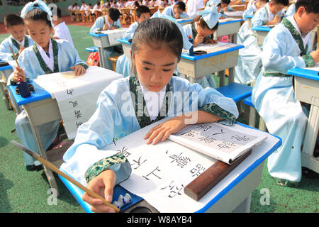 Junge Studenten calligraph chinesische Schriftzeichen bei der Eröffnung des ersten Longwan Bezirk Kalligraphie Kunst und Kultur Festival in Yongxin Stockfoto