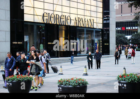 ---- Fußgänger vorbei ein Giorgio Armani store in Chongqing, China, 23. November 2015. Italienische Mode Haus Giorgio Armani erlebt eine langsame Stockfoto