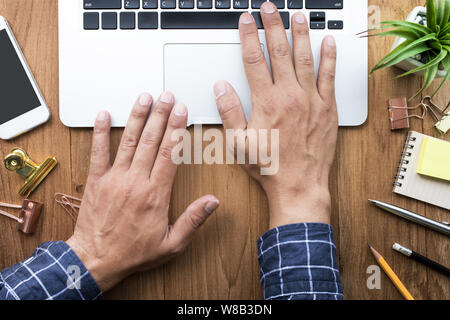 Männliche Hände arbeiten mit modernen Laptop auf Büro Schreibtisch Tisch und Zubehör Objekte. Business, Bildung Konzepte Ideen/flache Design legen Stockfoto