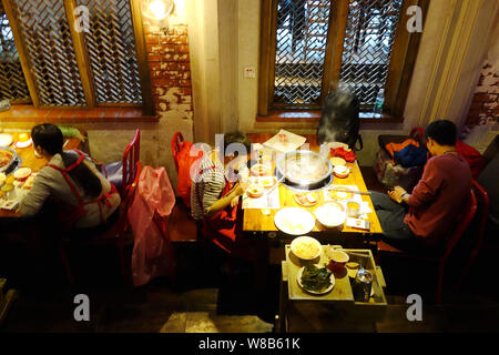 ------ Chinesische Kunden genießen Hot Pot im hotpot Restaurant in Chongqing, China, 23. März 2016. Hot Pot, das Fondue - wie Kochen - Ihr - eigenen - Gemüse Stockfoto