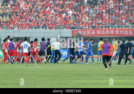 Spieler von Wuhan Hongxing Bairun F.C., (rot) und Jiangsu Suning Football Club (blau) wurde in einem Masse schlägerei am Ende der dritten Runde beteiligt Stockfoto