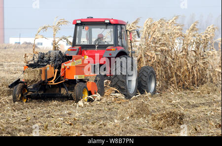 ---- Ein chinesischer Bauer fährt ein Traktor mit einem Ernte ausgestattet, weg zu Mais Stroh in einem Feld im Xuguang Dorf klar, Stadt Harbin, northea Stockfoto