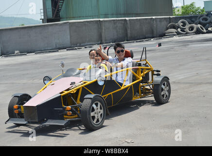 Chinesische auto Handwerker Wen Chao, rechts, testet seine hausgemachten Sportwagen, eine Nachbildung der Ariel Atom, mit seiner Frau und seinem Kind in einer Anlage in Wugong Stockfoto