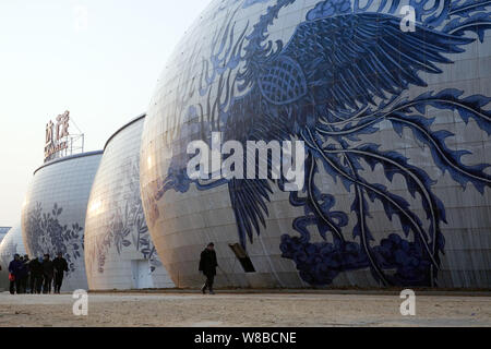 ------ Chinesische Wanderarbeiter vorbei ein Porzellan-themed Gebäudekomplex der Nanchang Wanda kulturellen Tourismus Stadt in Nanchang City, East China Stockfoto