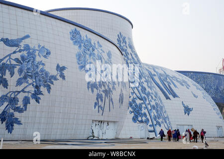 ------ Chinesische Wanderarbeiter vorbei ein Porzellan-themed Gebäudekomplex der Nanchang Wanda kulturellen Tourismus Stadt in Nanchang City, East China Stockfoto