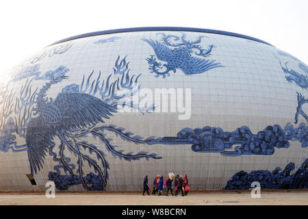 ------ Chinesische Wanderarbeiter vorbei ein Porzellan-themed Gebäudekomplex der Nanchang Wanda kulturellen Tourismus Stadt in Nanchang City, East China Stockfoto