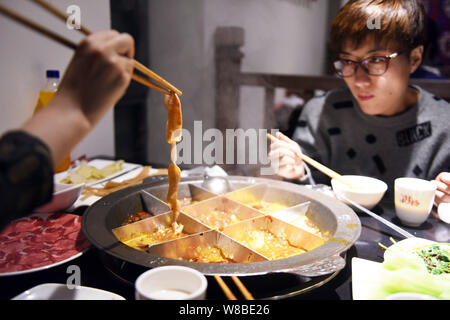 ------ Chinesische Kunden genießen Hot Pot im hotpot Restaurant in Peking, China, 31. Januar 2016. Hot Pot, das Fondue - wie Kochen - Ihr - eigenen - Gemüse - Stockfoto