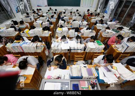 Chinesische Studenten überprüfung Lehrbücher in Vorbereitung auf die anstehenden nationalen Hochschuleingang Prüfung, auch als gaokao bekannt, in ihrem Klassenzimmer an der Gany Stockfoto