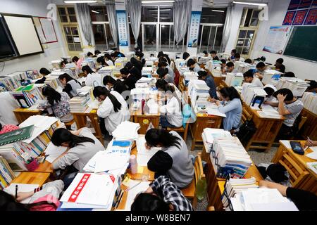 Chinesische Studenten überprüfung Lehrbücher in Vorbereitung auf die anstehenden nationalen Hochschuleingang Prüfung, auch als gaokao bekannt, in ihrem Klassenzimmer an der Gany Stockfoto