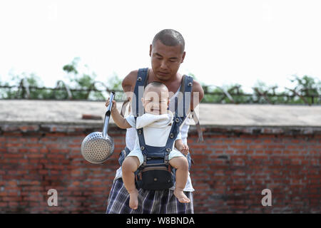 (190809) - Peking, August 9, 2019 (Xinhua) - Wang Gang spielt mit seinem Sohn Rourou im Hof seines Hauses an hexi Dorf Liangjiazi Township, Changtu Grafschaft der Stadt Tieling, Provinz Liaoning im Nordosten Chinas, Aug 8, 2019. Wang Gang, ein 33-jähriger Dorfbewohner von hexi Dorf der Provinz Liaoning, verlor seine Arme aufgrund einer versehentlichen elektrischen Schock im Alter von 13 Jahren. Nach Jahren der harten Praxis mit seinen Füßen, er kann nicht nur mit sich selbst, sondern auch einige einfache Hausarbeit und kümmern sich um seine kranke Mutter. Wang Gang mit Er Xiaoman vor vier Jahren und hatten ihren Sohn Rouro verheiratet Stockfoto