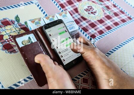 (190809) -- CHANGTU, August 9, 2019 (Xinhua) - Wang Gang prüft die Datensätze mit warmherzigen Menschen, die seine Familie helfen will, chatten, mit seinen Füßen an hexi Dorf Liangjiazi Township, Changtu Grafschaft der Stadt Tieling, Provinz Liaoning im Nordosten Chinas, Aug 8, 2019. Wang Gang, ein 33-jähriger Dorfbewohner von hexi Dorf der Provinz Liaoning, verlor seine Arme aufgrund einer versehentlichen elektrischen Schock im Alter von 13 Jahren. Nach Jahren der harten Praxis mit seinen Füßen, er kann nicht nur mit sich selbst, sondern auch einige einfache Hausarbeit und kümmern sich um seine kranke Mutter. Wang Gang mit Er Xiao verheiratet Stockfoto