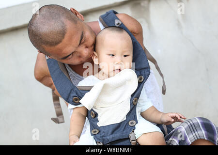 (190809) -- CHANGTU, August 9, 2019 (Xinhua) - Wang Gang spielt mit seinem Sohn Rourou im Hof seines Hauses an hexi Dorf Liangjiazi Township, Changtu Grafschaft der Stadt Tieling, Provinz Liaoning im Nordosten Chinas, Aug 8, 2019. Wang Gang, ein 33-jähriger Dorfbewohner von hexi Dorf der Provinz Liaoning, verlor seine Arme aufgrund einer versehentlichen elektrischen Schock im Alter von 13 Jahren. Nach Jahren der harten Praxis mit seinen Füßen, er kann nicht nur mit sich selbst, sondern auch einige einfache Hausarbeit und kümmern sich um seine kranke Mutter. Wang Gang mit Er Xiaoman vor vier Jahren und hatten ihren Sohn Rouro verheiratet Stockfoto