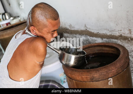 (190809) -- CHANGTU, August 9, 2019 (Xinhua) - Wang Gang bereitet zu Hause an hexi Dorf Liangjiazi Township, Changtu Landkreis Stadt Tieling zu kochen, im Nordosten der chinesischen Provinz Liaoning, Aug 8, 2019. Wang Gang, ein 33-jähriger Dorfbewohner von hexi Dorf der Provinz Liaoning, verlor seine Arme aufgrund einer versehentlichen elektrischen Schock im Alter von 13 Jahren. Nach Jahren der harten Praxis mit seinen Füßen, er kann nicht nur mit sich selbst, sondern auch einige einfache Hausarbeit und kümmern sich um seine kranke Mutter. Wang Gang mit Er Xiaoman vor vier Jahren und hatten ihren Sohn Rourou im Oktober 2018 geheiratet. Die Stockfoto