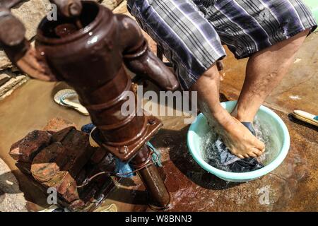 (190809) -- CHANGTU, August 9, 2019 (Xinhua) - Wang Gang wäscht Kleidung im Hof seines Hauses an hexi Dorf Liangjiazi Township, Changtu Grafschaft der Stadt Tieling, Provinz Liaoning im Nordosten Chinas, Aug 8, 2019. Wang Gang, ein 33-jähriger Dorfbewohner von hexi Dorf der Provinz Liaoning, verlor seine Arme aufgrund einer versehentlichen elektrischen Schock im Alter von 13 Jahren. Nach Jahren der harten Praxis mit seinen Füßen, er kann nicht nur mit sich selbst, sondern auch einige einfache Hausarbeit und kümmern sich um seine kranke Mutter. Wang Gang mit Er Xiaoman vor vier Jahren und hatten ihren Sohn Rourou in Octobe verheiratet Stockfoto