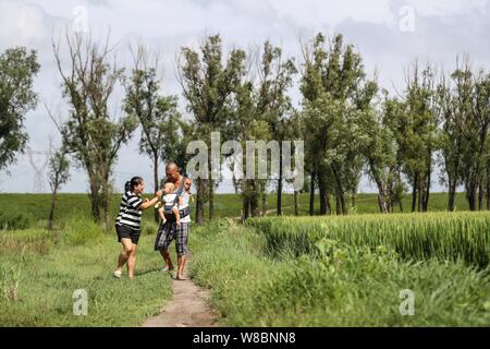 (190809) -- CHANGTU, August 9, 2019 (Xinhua) - Wang Gang und seine Frau, die er ihr Sohn Rourou Xiaoman nehmen einen Spaziergang an hexi Dorf Liangjiazi Township, Changtu Grafschaft der Stadt Tieling, Provinz Liaoning im Nordosten Chinas, Aug 8, 2019. Wang Gang, ein 33-jähriger Dorfbewohner von hexi Dorf der Provinz Liaoning, verlor seine Arme aufgrund einer versehentlichen elektrischen Schock im Alter von 13 Jahren. Nach Jahren der harten Praxis mit seinen Füßen, er kann nicht nur mit sich selbst, sondern auch einige einfache Hausarbeit und kümmern sich um seine kranke Mutter. Wang Gang mit Er Xiaoman vor vier Jahren und hatten ihre verheiratet Stockfoto