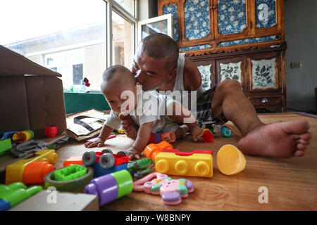 (190809) -- CHANGTU, August 9, 2019 (Xinhua) - Wang Gang spielt mit seinem Sohn zu Hause Rourou Hexi Dorf Liangjiazi Township, Changtu Grafschaft der Stadt Tieling, Provinz Liaoning im Nordosten Chinas, Aug 8, 2019. Wang Gang, ein 33-jähriger Dorfbewohner von hexi Dorf der Provinz Liaoning, verlor seine Arme aufgrund einer versehentlichen elektrischen Schock im Alter von 13 Jahren. Nach Jahren der harten Praxis mit seinen Füßen, er kann nicht nur mit sich selbst, sondern auch einige einfache Hausarbeit und kümmern sich um seine kranke Mutter. Wang Gang mit Er Xiaoman vor vier Jahren und hatten ihren Sohn Rourou im Oktober von 2 verheiratet Stockfoto