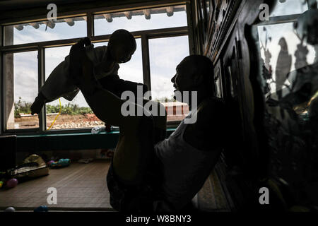 (190809) -- CHANGTU, August 9, 2019 (Xinhua) - Wang Gang spielt mit seinem Sohn zu Hause Rourou Hexi Dorf Liangjiazi Township, Changtu Grafschaft der Stadt Tieling, Provinz Liaoning im Nordosten Chinas, Aug 8, 2019. Wang Gang, ein 33-jähriger Dorfbewohner von hexi Dorf der Provinz Liaoning, verlor seine Arme aufgrund einer versehentlichen elektrischen Schock im Alter von 13 Jahren. Nach Jahren der harten Praxis mit seinen Füßen, er kann nicht nur mit sich selbst, sondern auch einige einfache Hausarbeit und kümmern sich um seine kranke Mutter. Wang Gang mit Er Xiaoman vor vier Jahren und hatten ihren Sohn Rourou im Oktober von 2 verheiratet Stockfoto