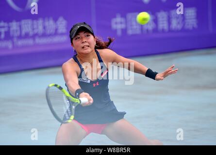 Riko Sawayanagi von Japan gibt einen Schuß zu Xu Shilin Chinas in singles ihre Frauen Match während der 2016 des ITF-Frauen-Nanning in Nanning Stockfoto