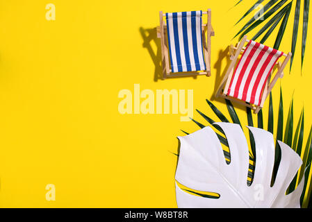 Flach am Strand Liegestühle, monstera und Palmblättern auf rosa Hintergrund mit kopieren. Sommer und Travel Concept. Kreative Banner. Stockfoto