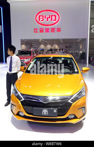 ---- Ein chinesischer Mitarbeiter stellt neben einen BYD Qin Plug-in Hybrid Auto auf dem Display während der 13 China (Guangzhou) Internationale Automobil Ausstellung Stockfoto