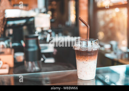 Zwei Ton Eiskaffee im Coffee Shop. Braune und weiße Eis Kaffee oder Caffe Latte mit Milch im Takeaway Cup. Kopieren Sie Platz für Text. Essen und Getränke backgrou Stockfoto