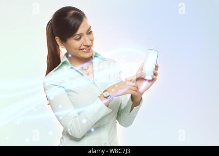 Geschäftsfrau, die ein Smartphone verwendet und von diesem Licht streamt Stockfoto