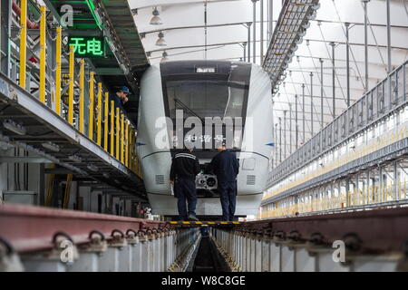 Chinesische Techniker untersuchen eine CRH (China Railway High speed) Bullet Train für die kommende Chinesisches Neujahrsfest oder Frühlingsfest zu einem maintena Stockfoto