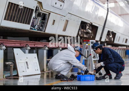 Chinesische Techniker untersuchen eine CRH (China Railway High speed) Bullet Train für die kommende Chinesisches Neujahrsfest oder Frühlingsfest zu einem maintena Stockfoto