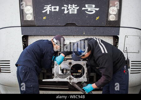 Chinesische Techniker untersuchen eine CRH (China Railway High speed) Bullet Train für die kommende Chinesisches Neujahrsfest oder Frühlingsfest zu einem maintena Stockfoto